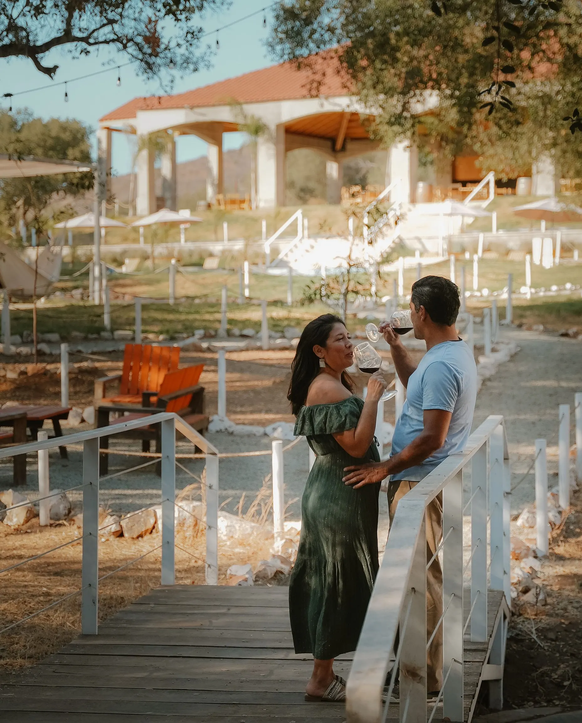 A couple toasting with wine on the boardwalk below the clubhouse