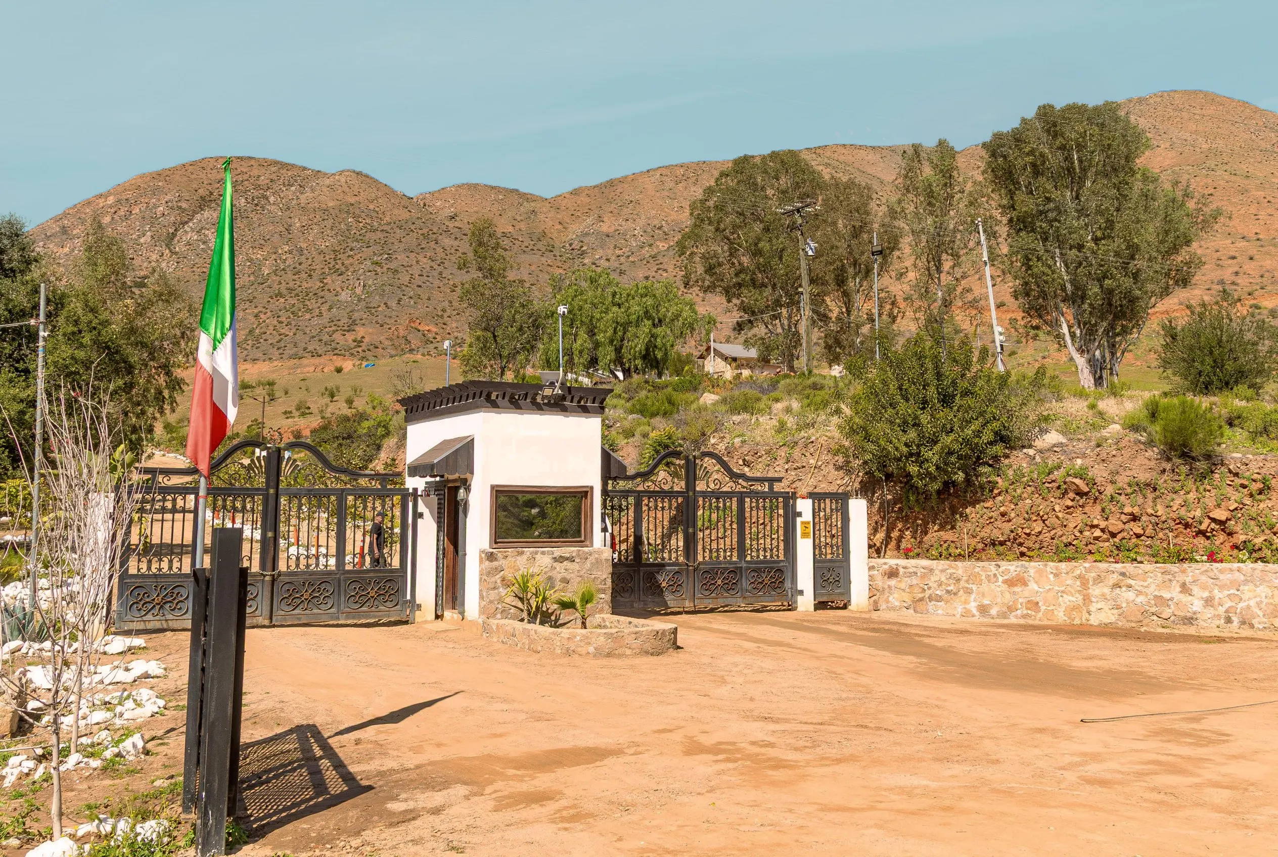 The gatehouse facade, with the flag and the hills behind