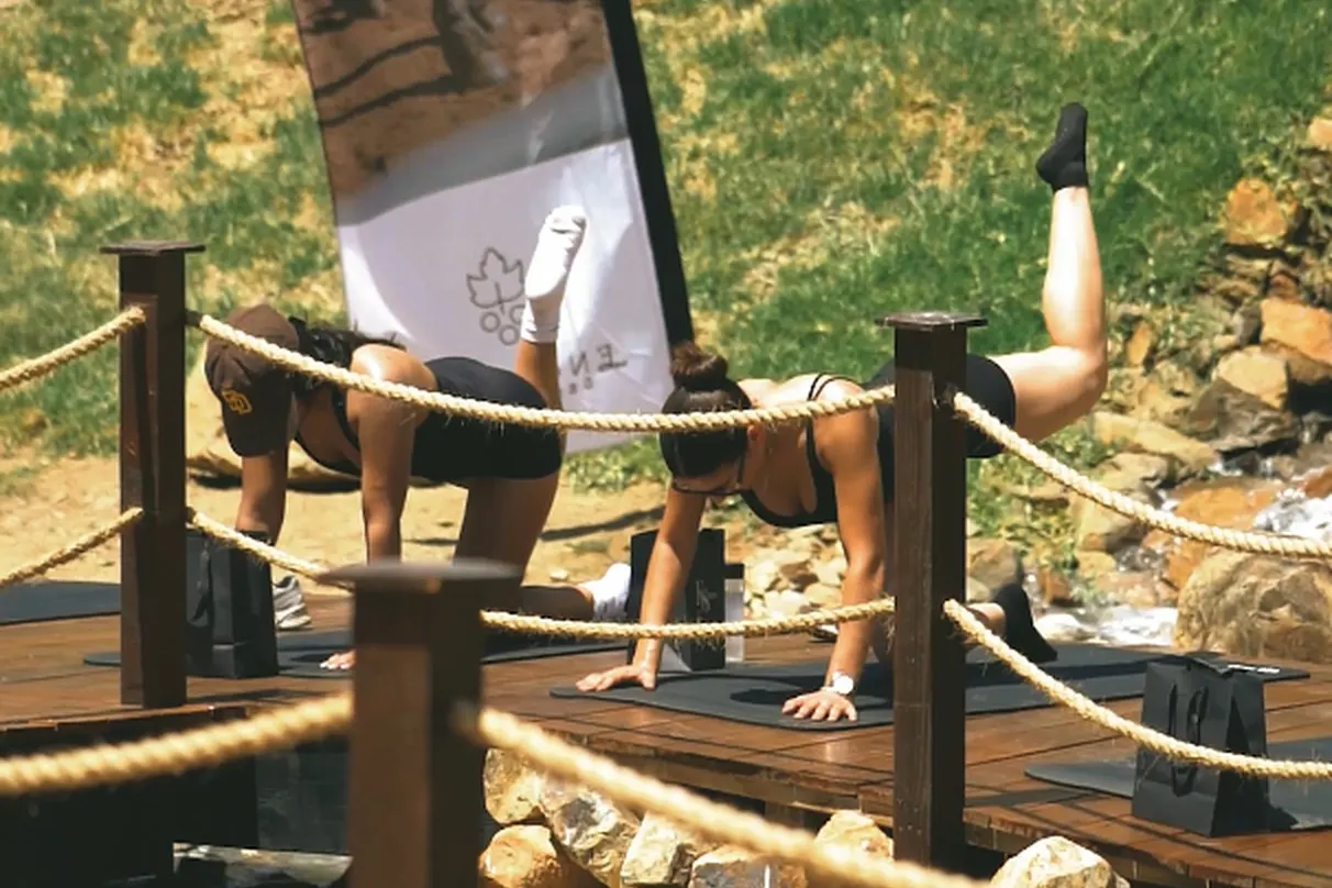 A yoga class on the wooden deck by the lake